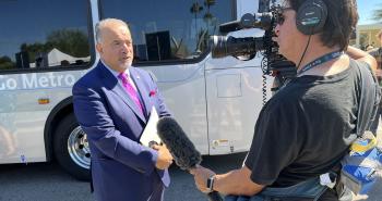 photo of camera man filming man in suit