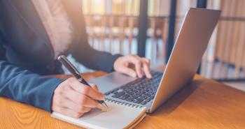 Individual with a laptop and notebook