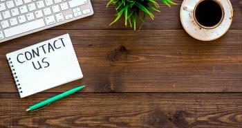 Notepad on desk stating Contact Us