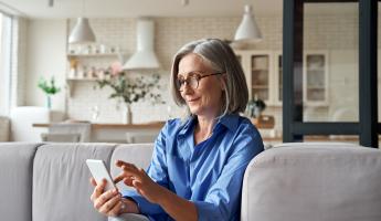 Women sitting on couch looking at cellphone