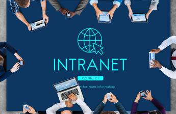Group of people around a table with text spellig Intranet 