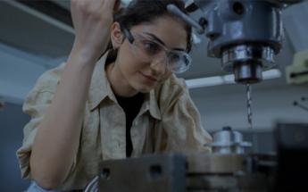 Female Student using machinery