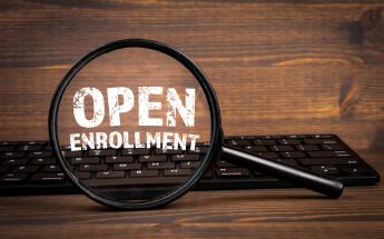 Magnifying glass over keyboard showing Open Enrollment