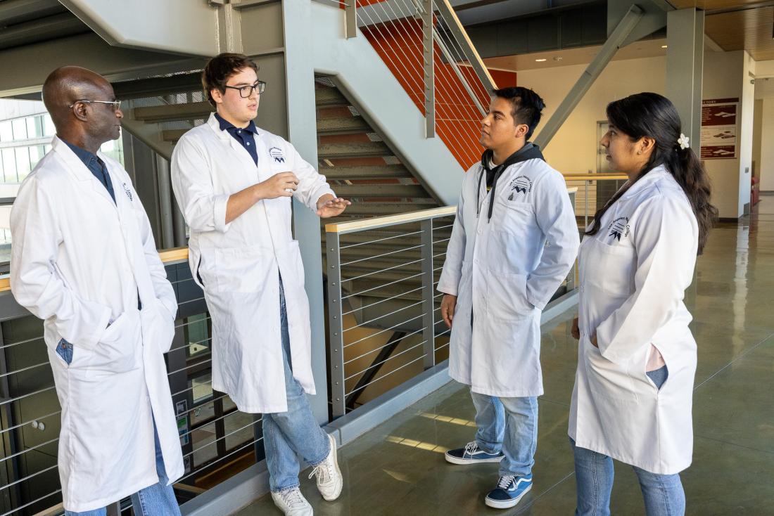 Biotechnology students discussing class with a teacherâs aide at Los Angeles Mission Collegeâs Center for Math & Science building