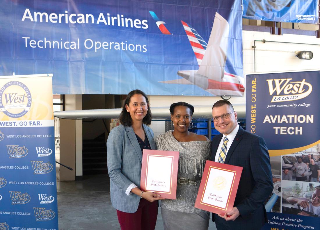 American Airline Vice President Evita Garces and WLAC Vice President Jeffrey Archibald receive proclamations from a representative of Senator Smallwood-Cuevas