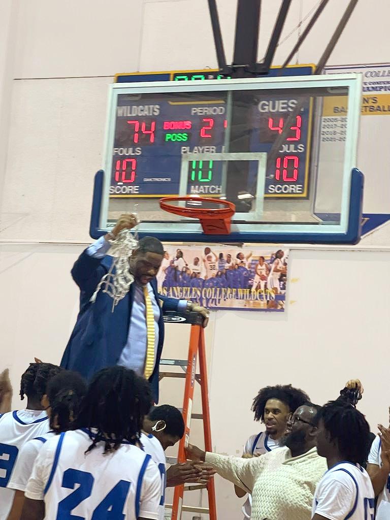 Athletics Director / Head Coach Anthony Jones cuts down basketball net after victory over Saddleback College