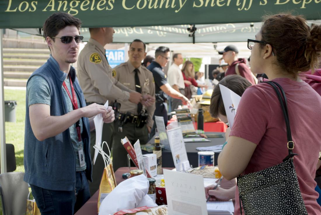 A student speaking with an employer tabling at the Spring Job Fair