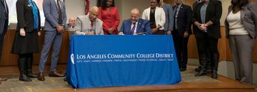 CSUDH President Thomas A. Parham (seated, left) and LACCD Chancellor Francisco C. Rodriguez (seated, right) signing the Memorandum of Understanding.