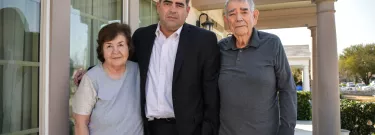 Gabriel Buelna stands for a portrait with his parents in front of their South Los Angeles home, where Buelna was raised.