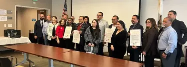 ELAC faculty, UNIVO officials, a Salvadoran official, and a couple students pose for a photo at the partnership signing event.