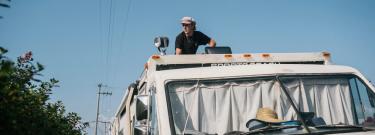 homeless student on top of an RV